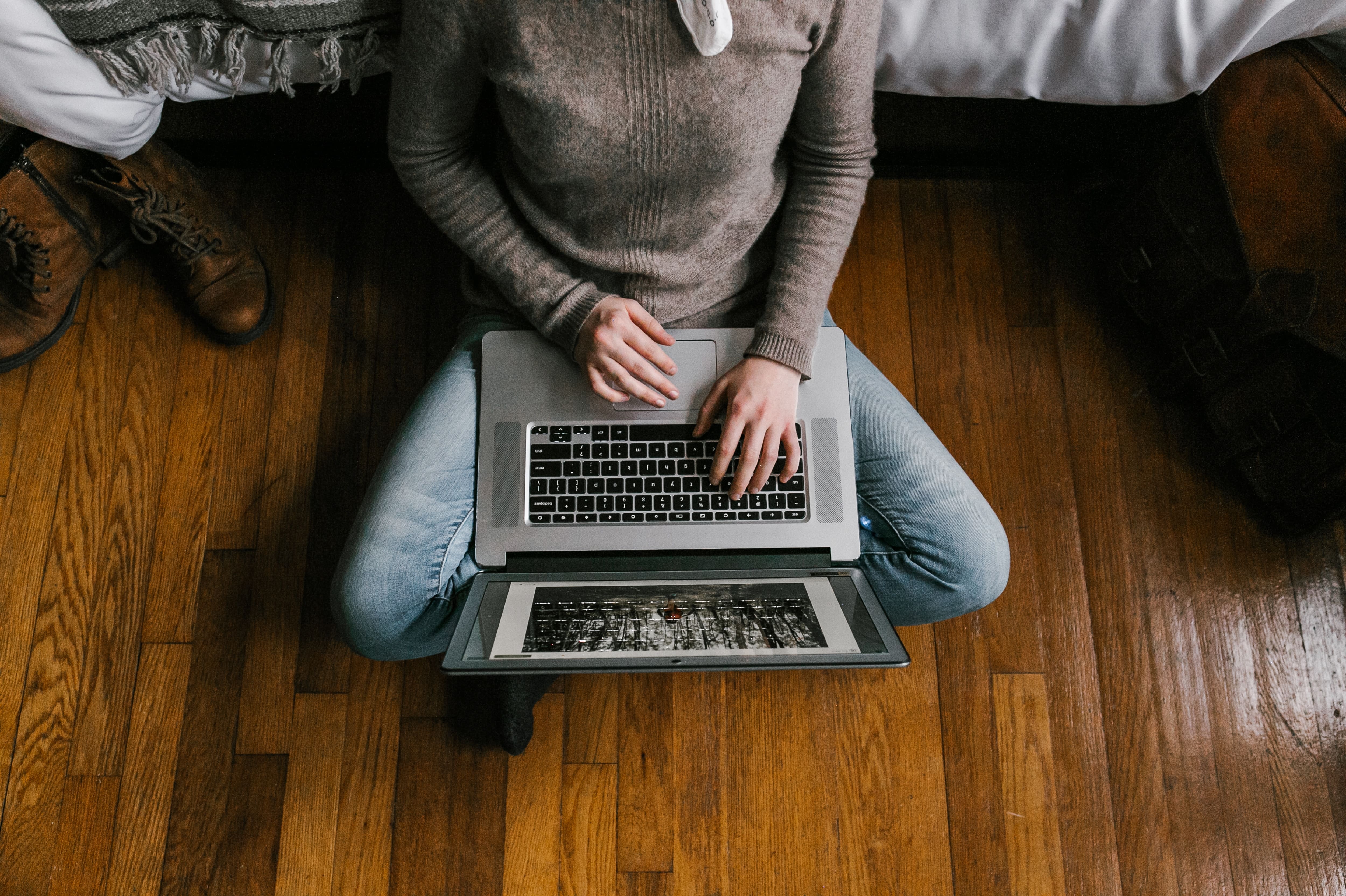 woman using laptop on hardwood floor