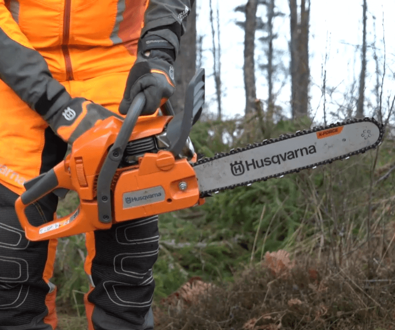 person holding a Husqvarna chainsaw