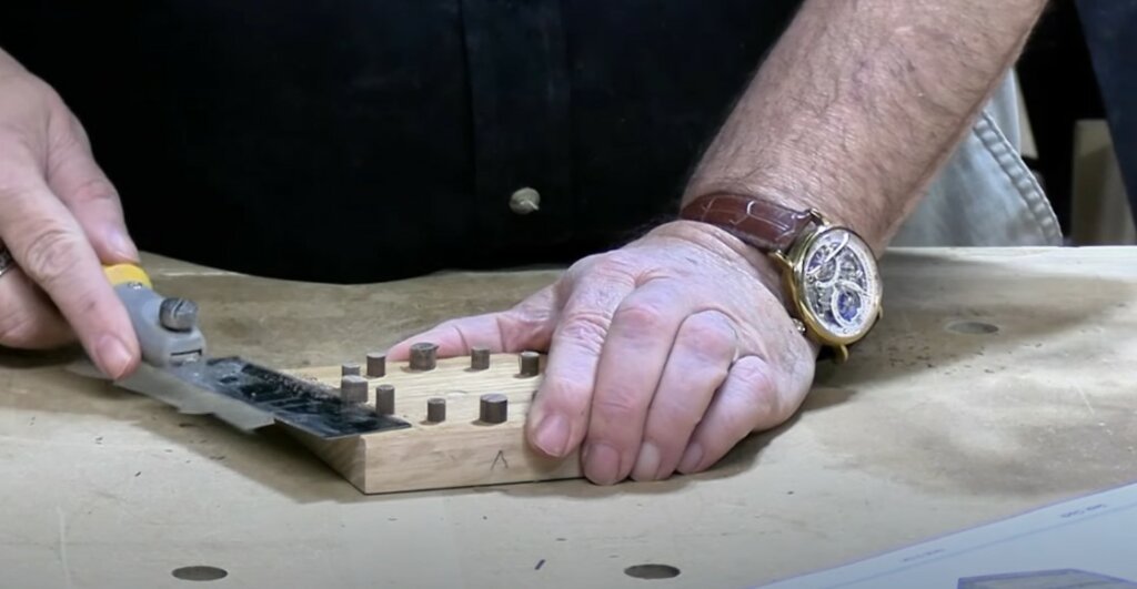 Cutting the excess walnut rods on the black of the clock