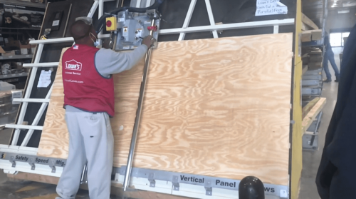 Lowe's employee cutting plywood