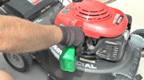 adding oil to lawn mower