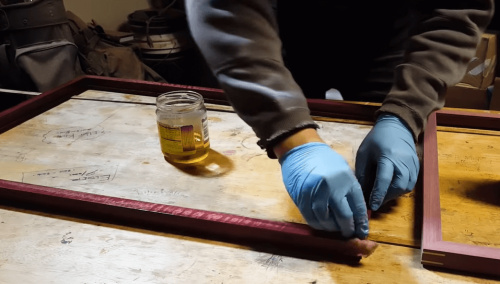 applying tung oil to wooden frame