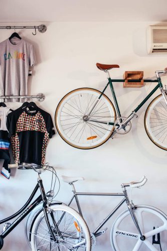 shirts hanging and a bicycle mounted on a wooden hanger
