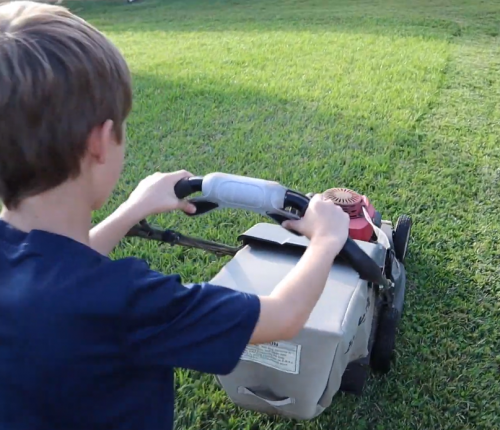 boy mowing the lawn