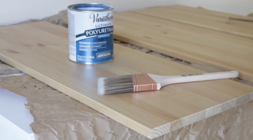 can of polyurethane and paint brush