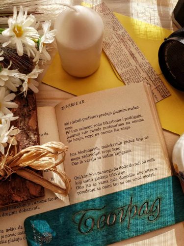 flowers, candle, book and a teal wooden bookmark