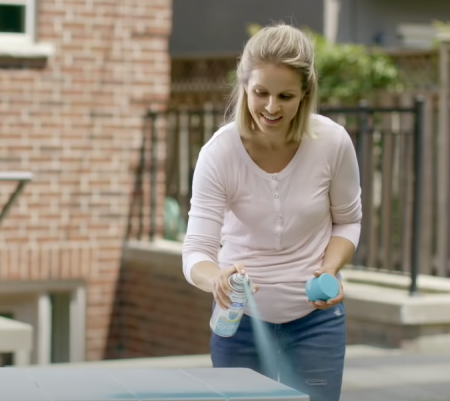 lady spray painting a white table
