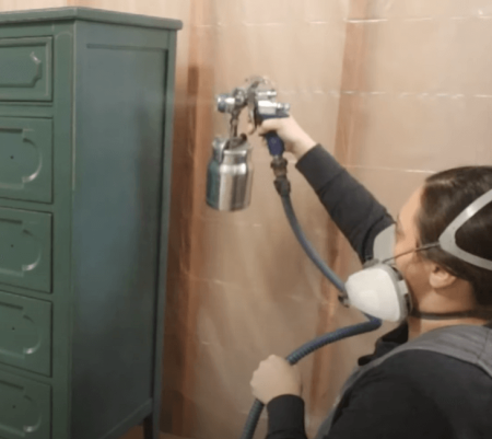 lady spraying cabinet with polyurethane