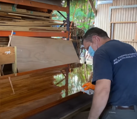 man applying paint on wooden board