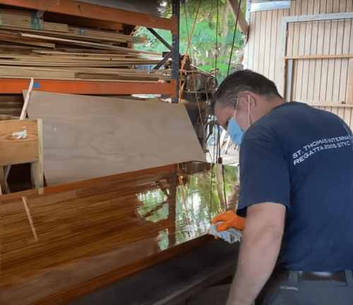 man applying paint on wooden board