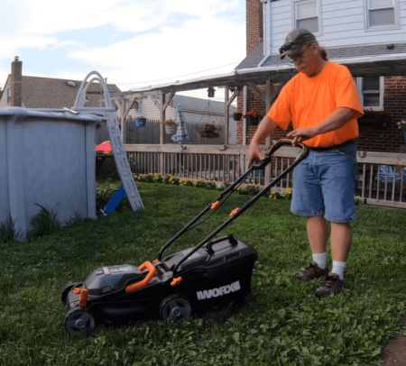 man operating Worx WG744 Cordless Push Mower