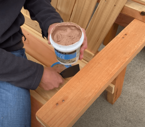 person holding FamoWood 40022126 Latex Wood Filler