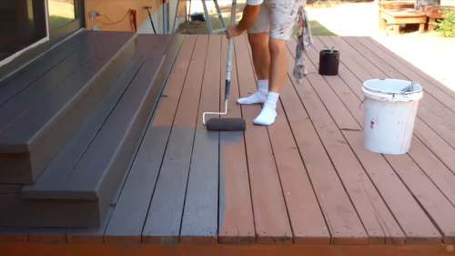 person staining the deck