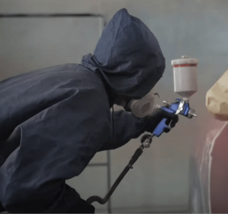 person wearing protective gear while spray painting