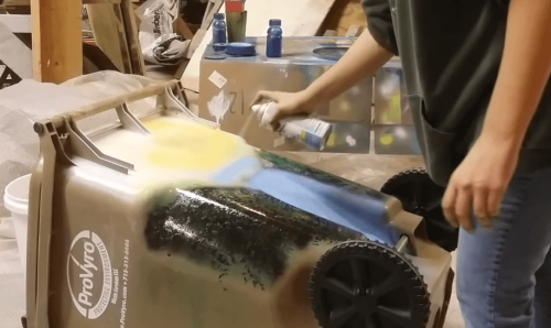 spray painting garbage can