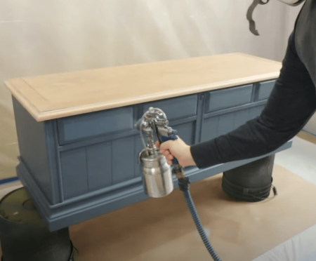 spraying polyurethane over painted cabinet